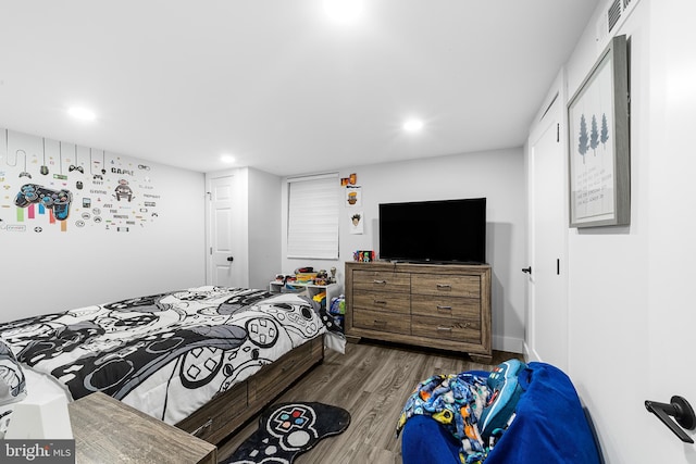 bedroom with recessed lighting and wood finished floors