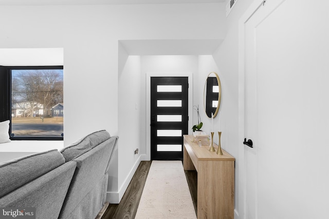 entryway with dark wood-style floors, baseboards, and visible vents