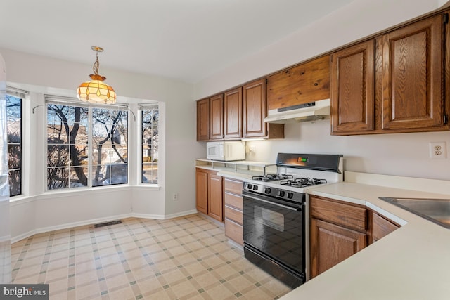 kitchen featuring visible vents, light countertops, brown cabinetry, gas stove, and under cabinet range hood