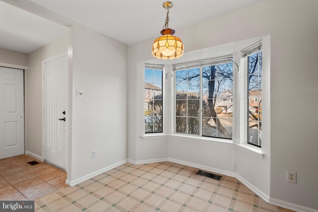 unfurnished dining area featuring tile patterned flooring, visible vents, and baseboards