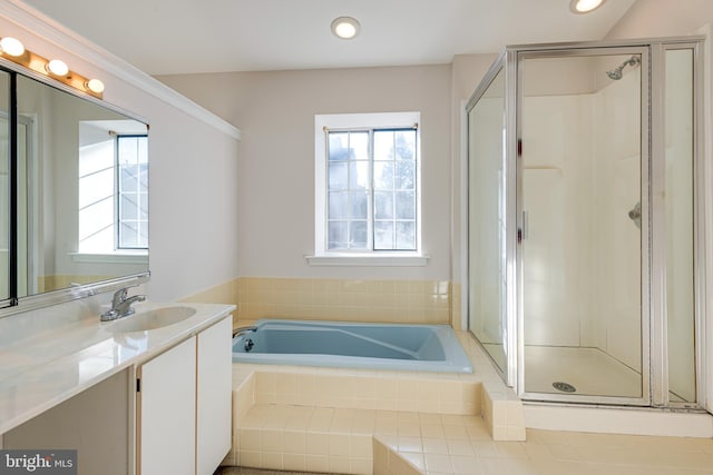 full bathroom featuring plenty of natural light, a garden tub, vanity, and a shower stall