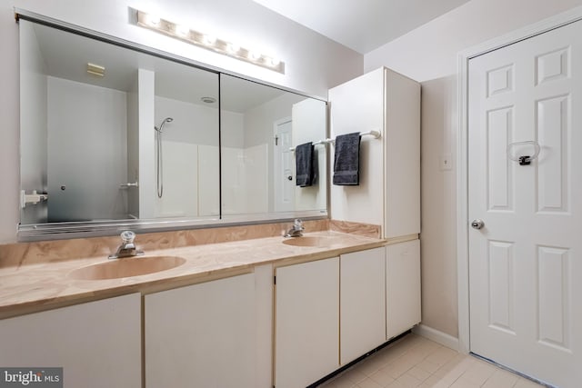 full bath with double vanity, a sink, and tile patterned floors