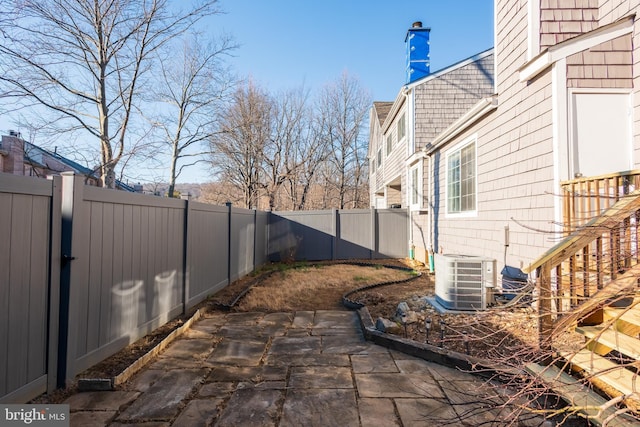 view of side of home featuring cooling unit, a patio area, and a fenced backyard