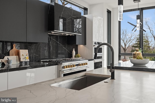 kitchen featuring stone counters, extractor fan, double oven range, decorative backsplash, and modern cabinets