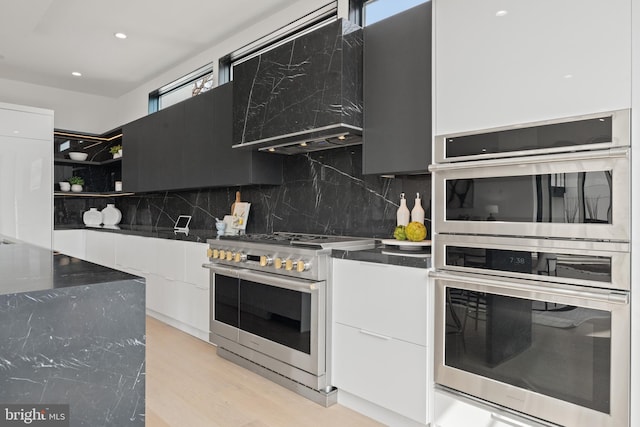 kitchen featuring open shelves, stainless steel appliances, decorative backsplash, light wood-style floors, and modern cabinets