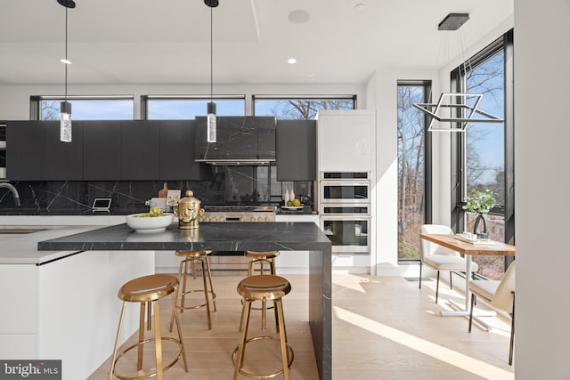 kitchen with dark countertops, a breakfast bar area, stainless steel appliances, and decorative backsplash