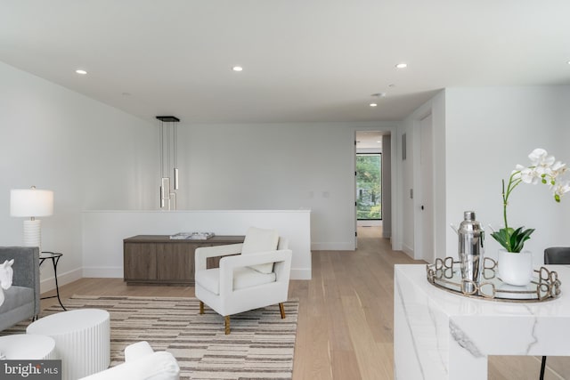 living room featuring recessed lighting, baseboards, and light wood finished floors