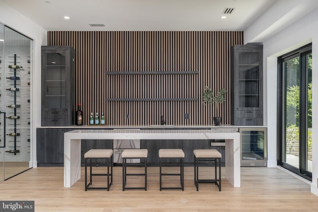 bar featuring light wood-style floors, wine cooler, visible vents, and recessed lighting