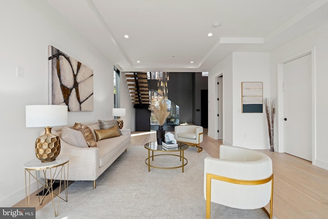 living area with baseboards, a tray ceiling, wood finished floors, and recessed lighting