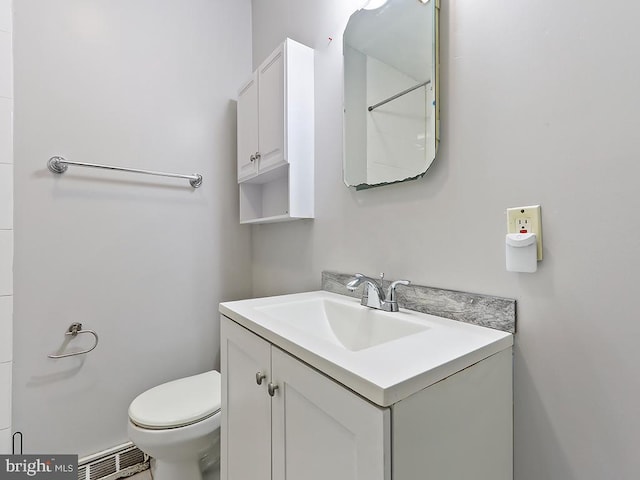 bathroom with baseboard heating, visible vents, vanity, and toilet