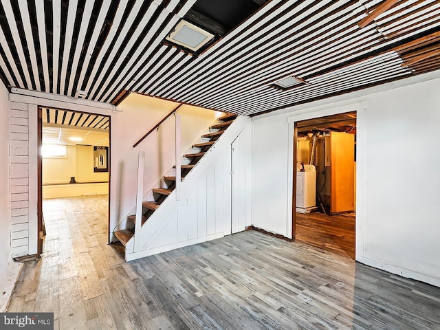 finished basement with stairway, washer / clothes dryer, and wood finished floors