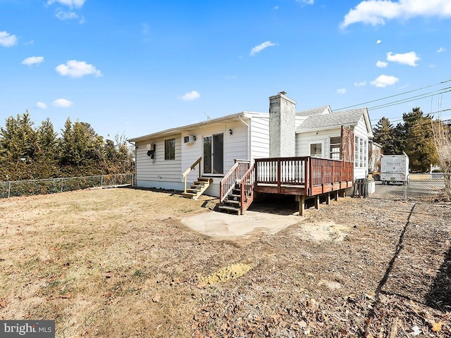 back of property featuring entry steps, a fenced backyard, a chimney, and a wooden deck