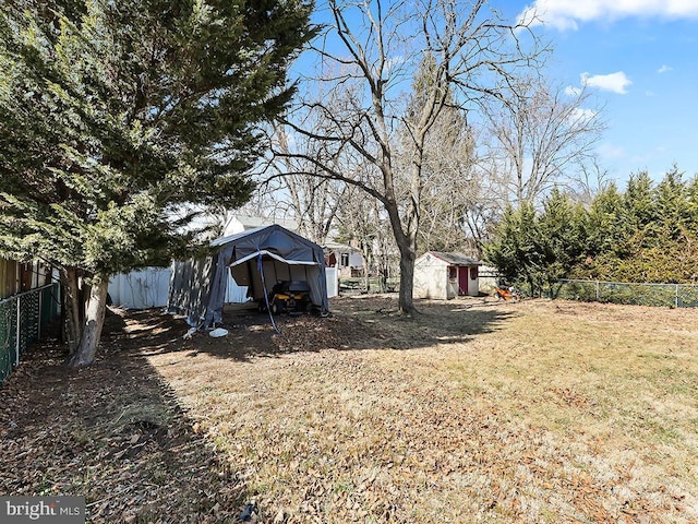 view of yard with a shed, an outdoor structure, and a fenced backyard