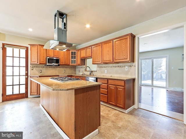 kitchen featuring light stone counters, backsplash, appliances with stainless steel finishes, ornamental molding, and a sink