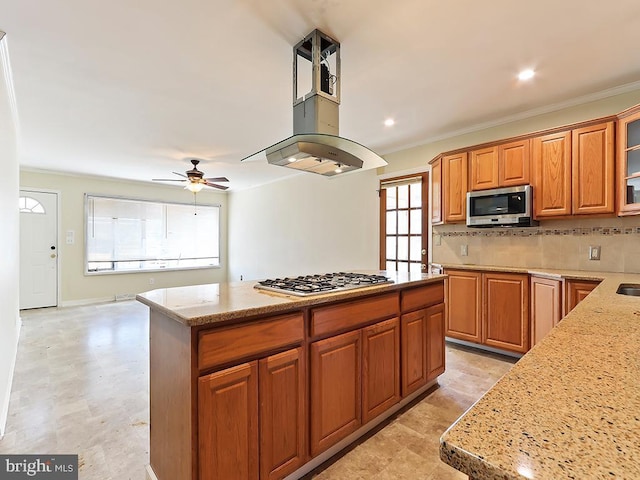 kitchen featuring a center island, stainless steel appliances, backsplash, glass insert cabinets, and light stone countertops