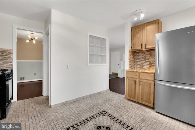 kitchen featuring a chandelier, light tile patterned flooring, visible vents, black gas stove, and freestanding refrigerator
