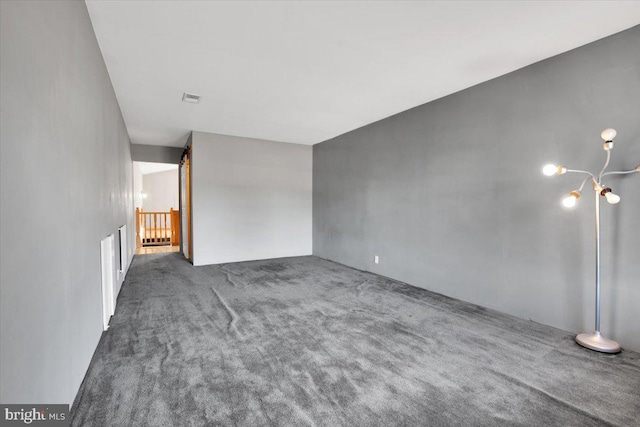 spare room with visible vents and carpet flooring