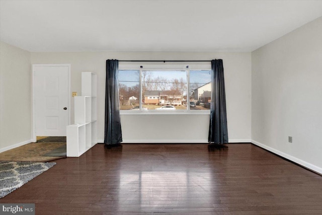 empty room featuring baseboards and wood finished floors