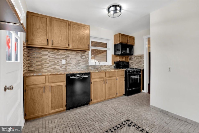 kitchen featuring baseboards, a sink, black appliances, backsplash, and light tile patterned flooring