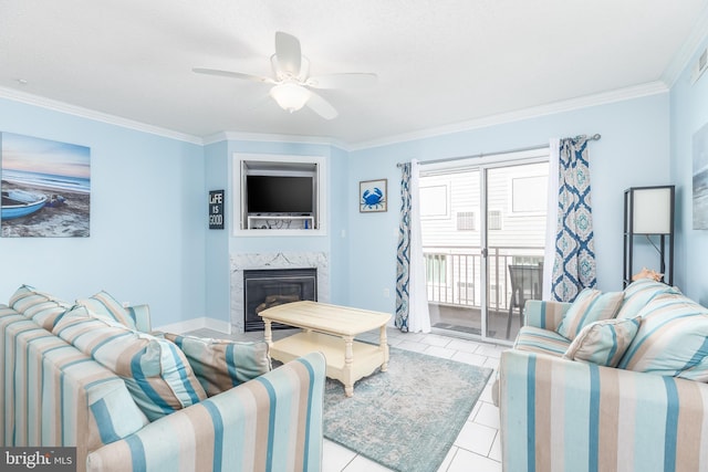 living area featuring ceiling fan, ornamental molding, a fireplace, and tile patterned flooring