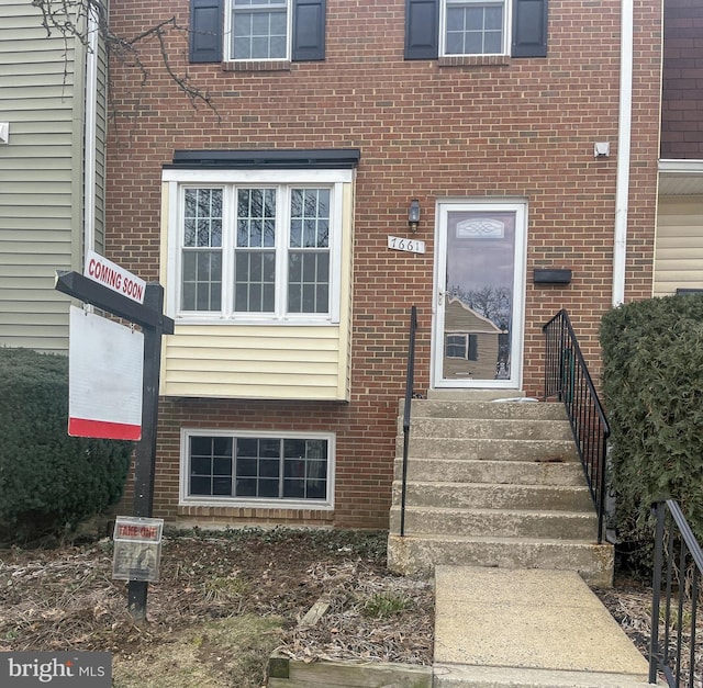 doorway to property featuring brick siding