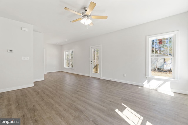 unfurnished living room with recessed lighting, ceiling fan, baseboards, and wood finished floors