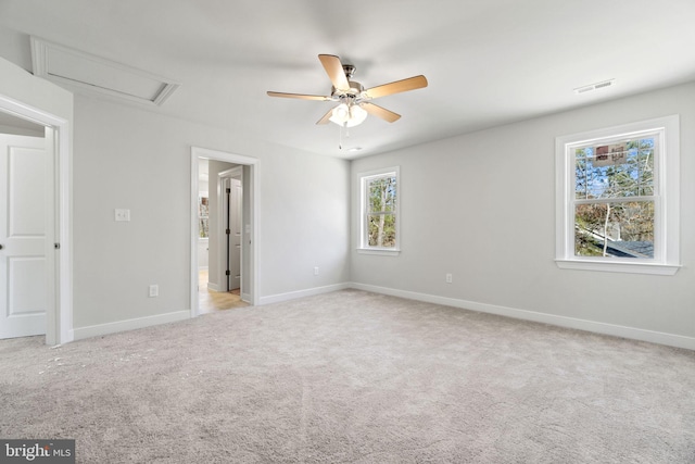 unfurnished bedroom with attic access, light carpet, visible vents, and baseboards