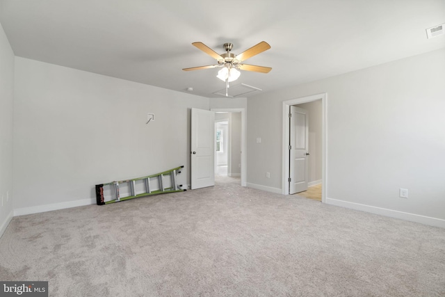 carpeted spare room with a ceiling fan, visible vents, and baseboards