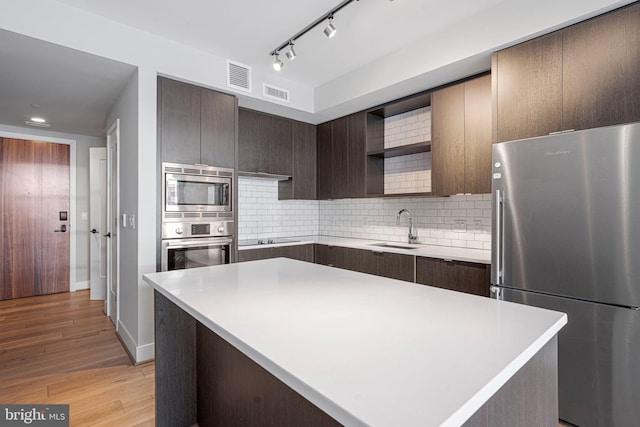 kitchen featuring appliances with stainless steel finishes, visible vents, a sink, and open shelves