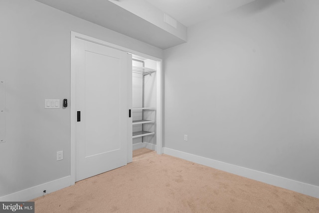 unfurnished bedroom with carpet floors, a closet, and baseboards