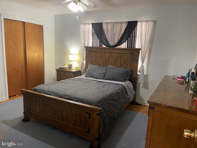 bedroom featuring ceiling fan, a closet, and light wood-style floors