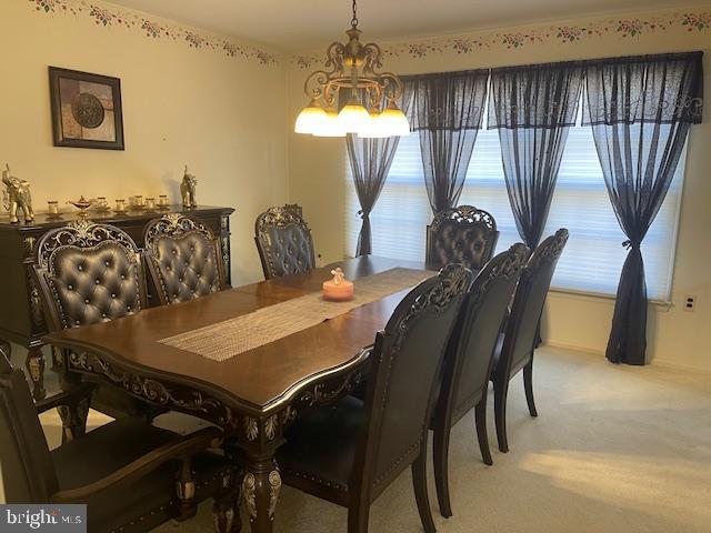 dining area with a chandelier and carpet flooring