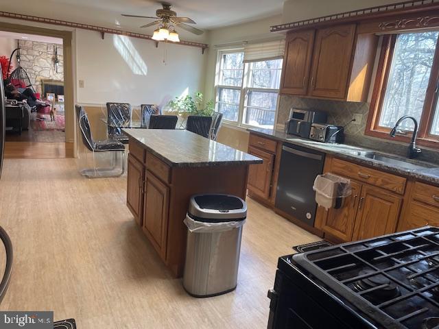 kitchen featuring a healthy amount of sunlight, black appliances, and brown cabinetry