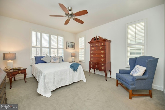 bedroom with light colored carpet, ceiling fan, and baseboards