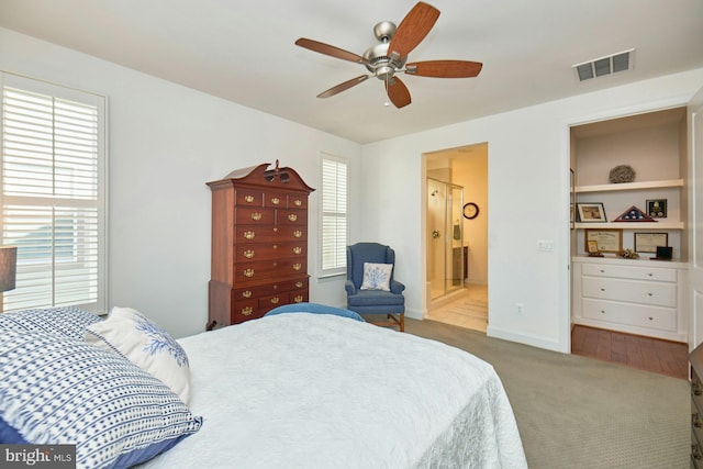 bedroom with carpet floors, visible vents, ceiling fan, ensuite bath, and baseboards