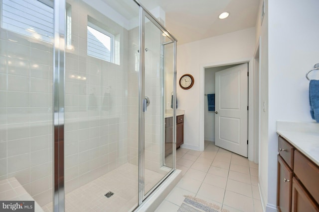 bathroom featuring baseboards, tile patterned floors, vanity, a shower stall, and recessed lighting