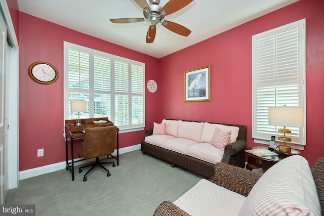 carpeted office space with baseboards and a ceiling fan