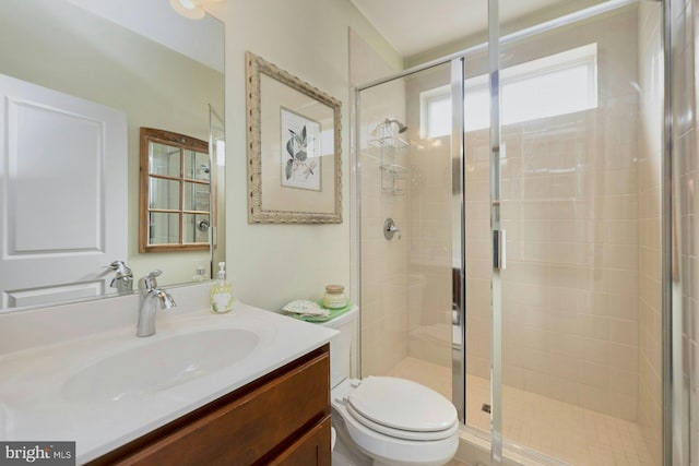 bathroom with toilet, a shower stall, and vanity