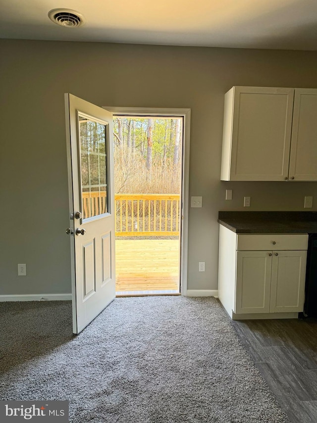 interior space with baseboards, visible vents, and dark carpet