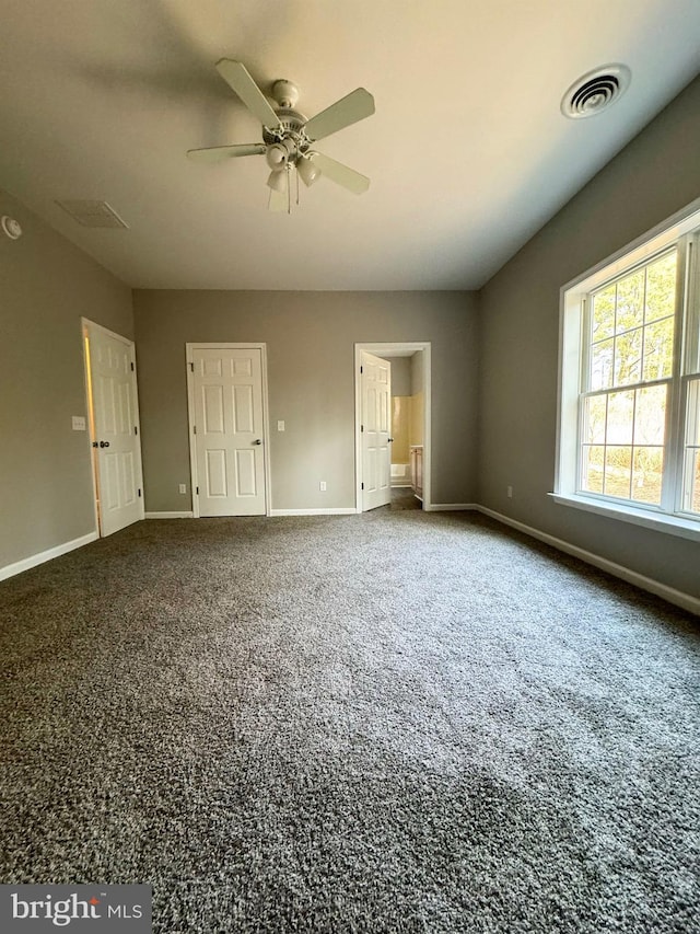 unfurnished bedroom with carpet floors, visible vents, and baseboards