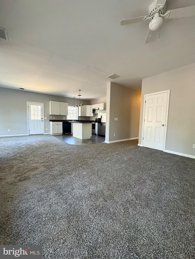 unfurnished living room featuring a ceiling fan, visible vents, dark carpet, and baseboards