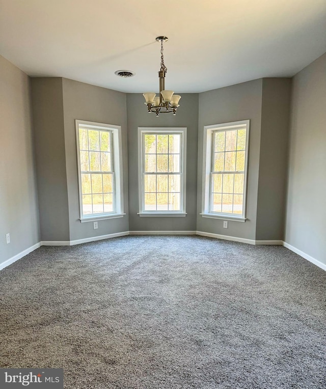 unfurnished room featuring a notable chandelier, carpet, visible vents, and baseboards