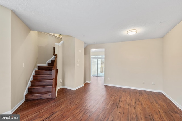 interior space featuring baseboards, stairway, and wood finished floors