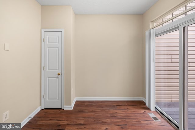 empty room featuring visible vents, baseboards, and wood finished floors