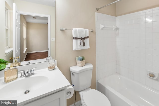 bathroom featuring toilet, shower / bathtub combination, and vanity