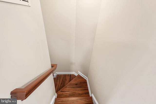 stairs with wood finished floors and baseboards