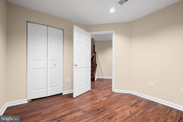 unfurnished bedroom featuring visible vents, baseboards, dark wood-style flooring, a closet, and recessed lighting