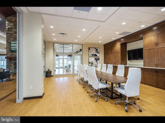 dining room with baseboards, visible vents, light wood-style flooring, and a drop ceiling