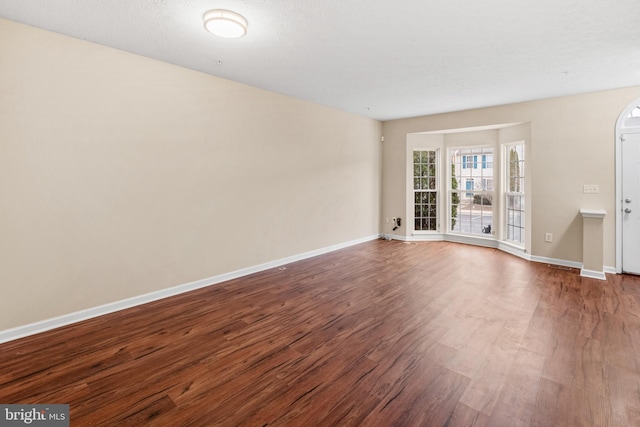 empty room featuring baseboards and wood finished floors