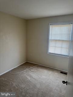 empty room with baseboards, carpet, and visible vents